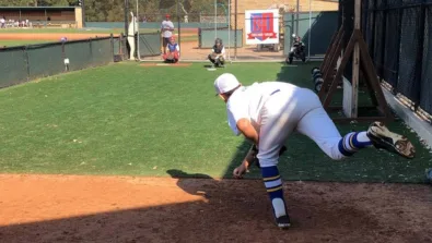 Baseball pitcher follows through on throw to catcher in bullpen