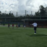 Coach on pitchers mound directing campers at first base
