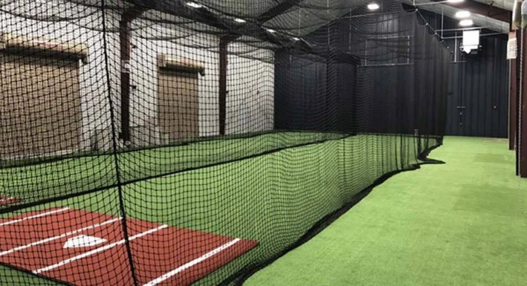 Indoor batting cage enclosed by black netting