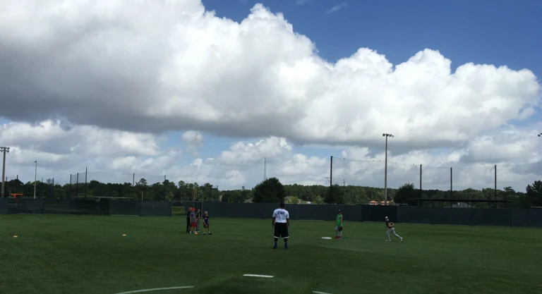 Campers going through fielding drill in the outfield on a cloudy day