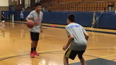 Saint Anselm College youth boys doing one on one basketball scrimmage