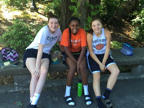 Lewis Clark College girls smiling and making friends at youth basketball camp in oregon