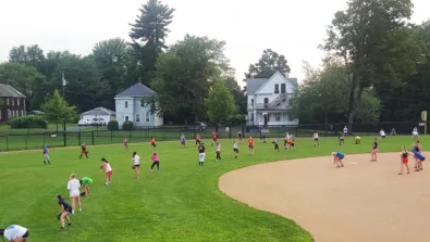 Softball campers lined up in the outfield for drill