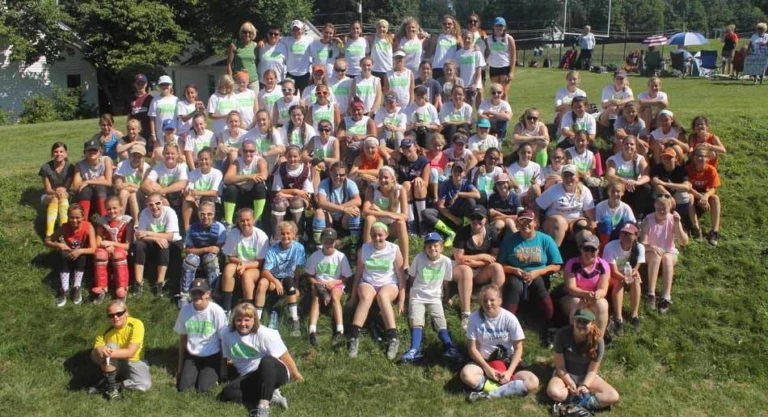 Campers sit on hillside for group picture at Nike Softball Camp Amherst College
