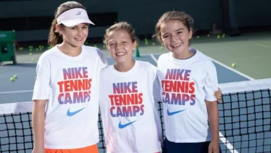 Tennis girls smiling in front of net
