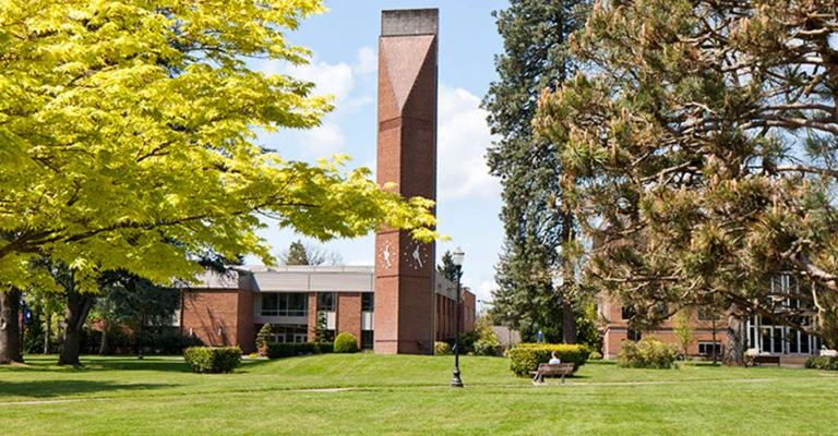 Clock tower on grassy field on George Fox University Campus